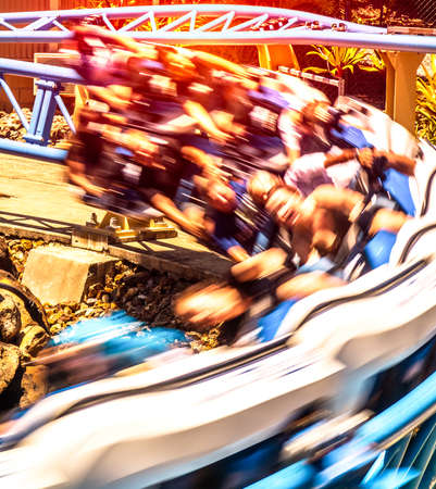 A group of people is whipped around a corner on a roller coasterの写真素材