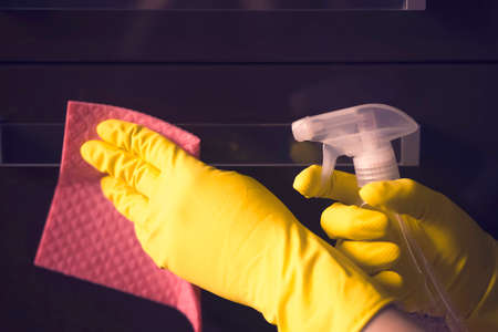 A woman in yellow rubber gloves does houseworkの写真素材