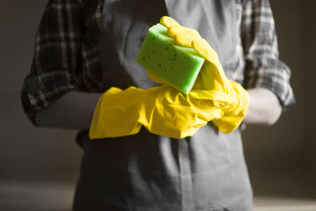 A woman in yellow rubber gloves does houseworkの写真素材
