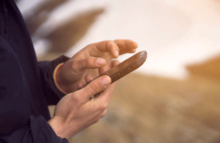 Man holds a smartphone in his hands and looks at a map.の写真素材