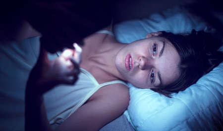 A young girl lies in bed and cannot sleep.