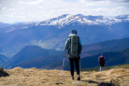 The traveler looks at the stunning view of the snow-capped mountains at sunset.の写真素材