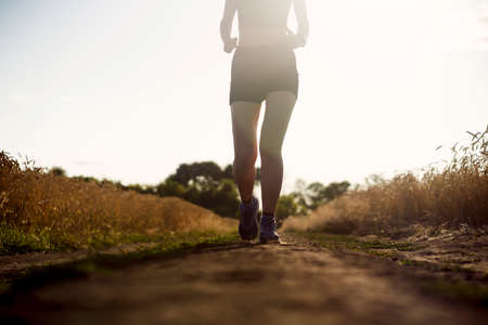 Man jogging along the trail at sunset.の写真素材