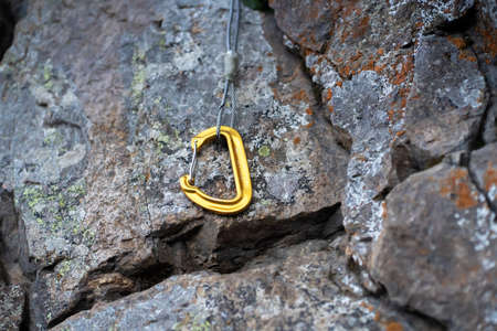 Yellow carabiner lies on the rock.の写真素材