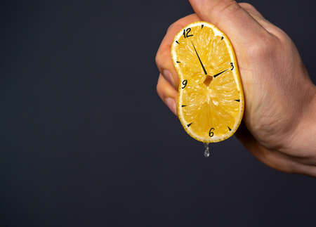 Hand squeezes out a lemon, on which the clock is drawn.