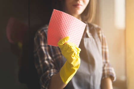 A woman in yellow rubber gloves does houseworkの写真素材