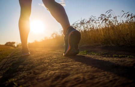 Athlete runner legs running on a close-up of a trail across a field.の写真素材