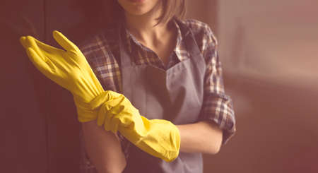 A woman in yellow rubber gloves does houseworkの写真素材