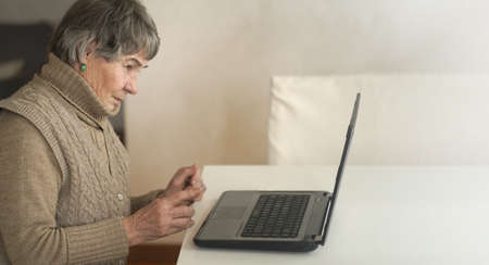 Old woman reading news online.の写真素材