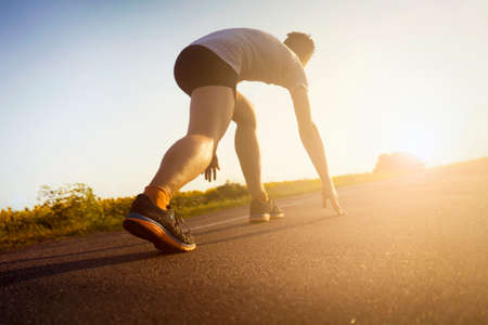 Young man is running, training outdoor at suset.の写真素材
