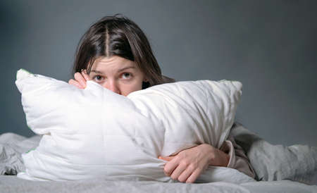 Woman covered with a blanket and is worried about insomnia, getting stress.の写真素材