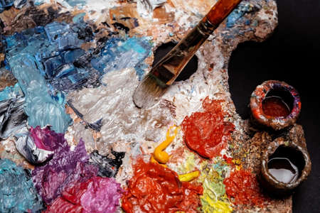 Brush mixing bright colors from relief layers of oil paintsの写真素材