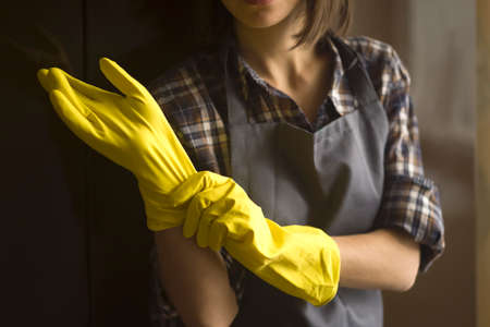 A woman in yellow rubber gloves does houseworkの写真素材