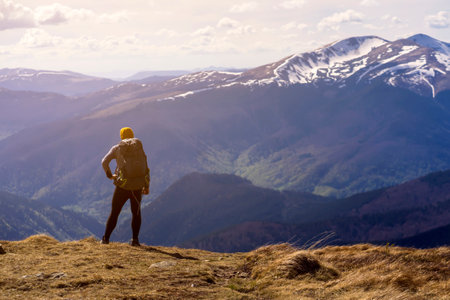 The traveler looks at the stunning view of the snow-capped mountains at sunset.
