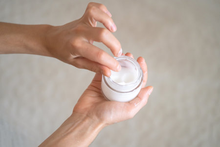 Female hands hold a jar of moisturizing cream.の写真素材