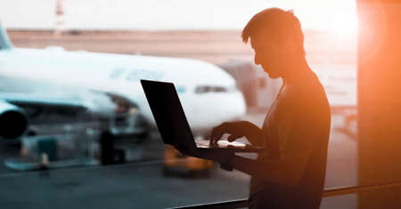 A young man is working on a laptop