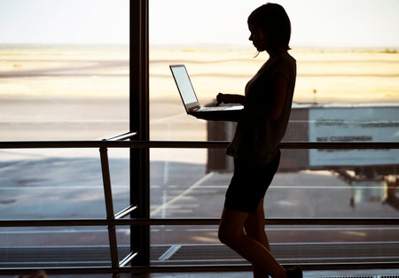 Girl works on a laptop at the airport.の写真素材
