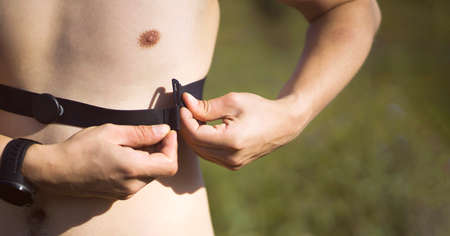 Man with a smatwatch and heart rate monitor outdoor.の写真素材