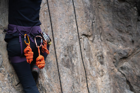 Girl is climbing in the mountains with a rope.