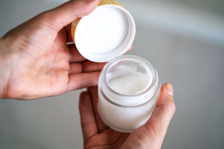 Girl holds a jar with a cream in her hands.の写真素材