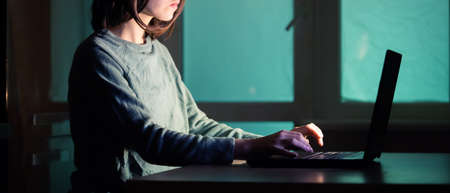 The girl works on the laptop at night.の写真素材