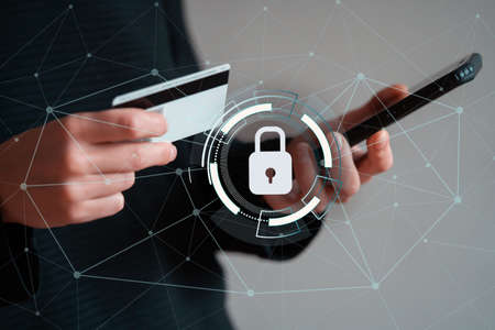 Girl holds bank card and mobile phone in her hands.の写真素材