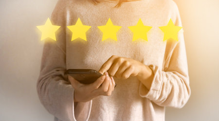 Girl is rating "five star" using a mobile phone.の写真素材