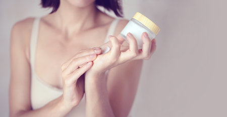 Female hands hold a jar of moisturizing creamの写真素材