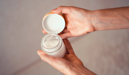 Female hands hold a jar of moisturizing cream.の写真素材