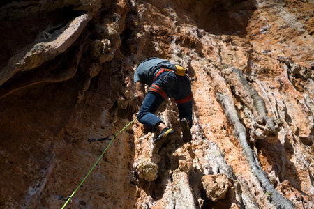 Young man is climbing on the rocks in the mountains.の写真素材