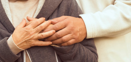 Man is holding hands of his beloved woman, closeup view.