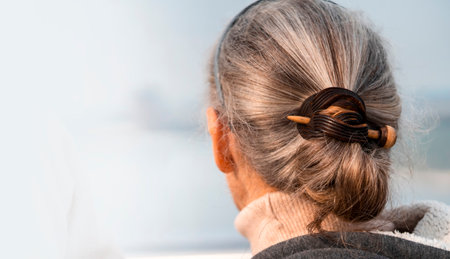 An elderly woman with a silver gray hair, fastened with a hairpin.の写真素材