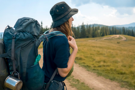 Young girl in a hat is trekking, hiking in the mountains.の写真素材
