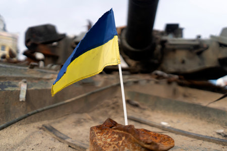 Ukrainian flag on the background of destroyed military equipmentの写真素材
