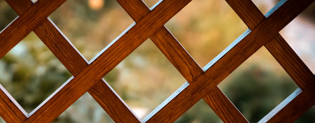 Wooden lattice, a decorative fence with garden on the background.の写真素材