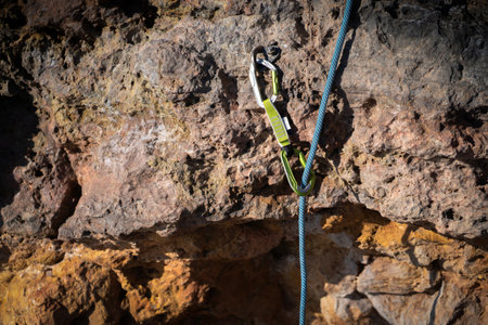Climbing tools, a carabiner with a rope on the rock closeup.の写真素材