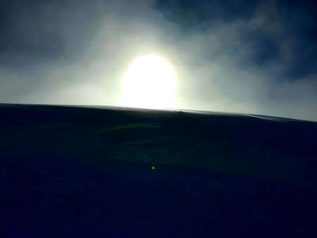 A close-up beautiful photo of the sun hiding behind the high mountainsのeditorial素材