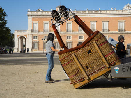 A hot air balloon pilot unloads the balloon's basket in preparation to raise the balloon in Aranjuez, Madrid, September, 2017のeditorial素材