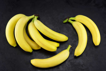 Yellow bananas, it's interesting laid out on a dark backgroundの写真素材