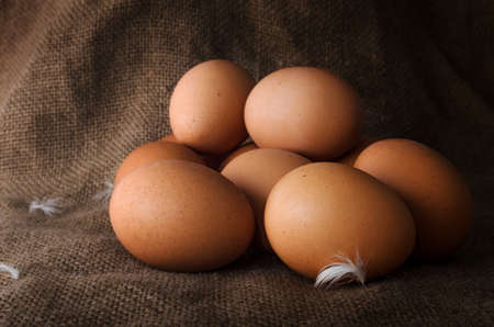Fresh raw chicken eggs closeup on a dark background burlapの写真素材