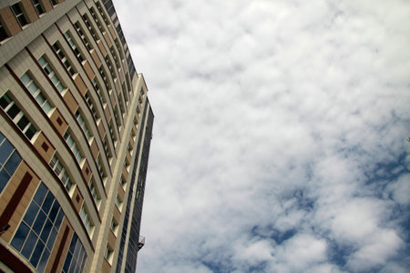 business concept - modern block of offices against cloudy sky underside viewの写真素材