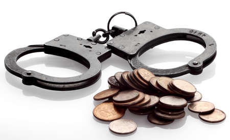 Concept - Handcuffs and coins isolated on white の写真素材