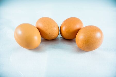 fresh four eggs  on blue backgroundの写真素材
