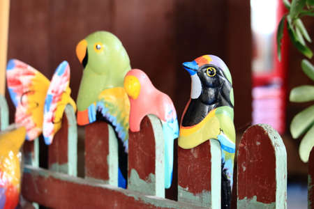 Colorful Bird Model On The Red Fenceの写真素材