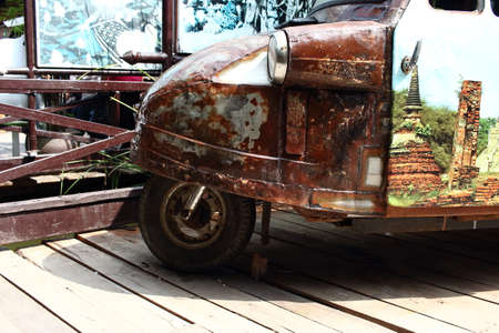 Old Rusty Tuk Tuk Parked On Wooden Floorの写真素材