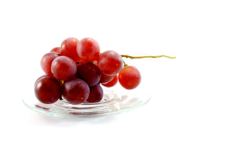 A Bunch of Red Grapes In Clear Dish On White Backgroundの写真素材