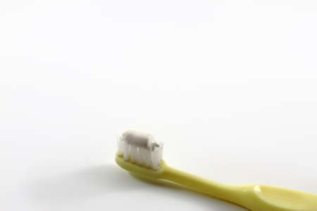 A Yellow Toothbrush With Toothpaste On White Backgroundの写真素材