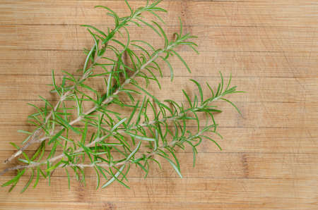 rosemary herb twigs on wooden backgroundの写真素材