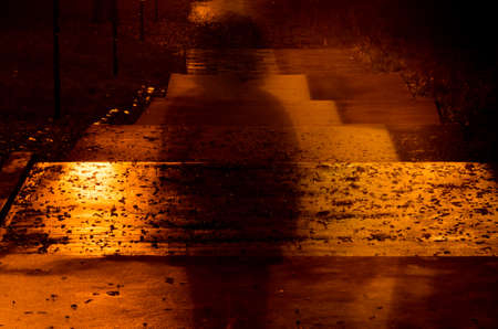 blurred person silhouette in dark alleyの写真素材