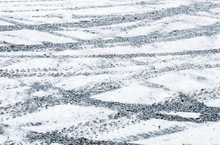 tire tracks on ground covered with snowの写真素材